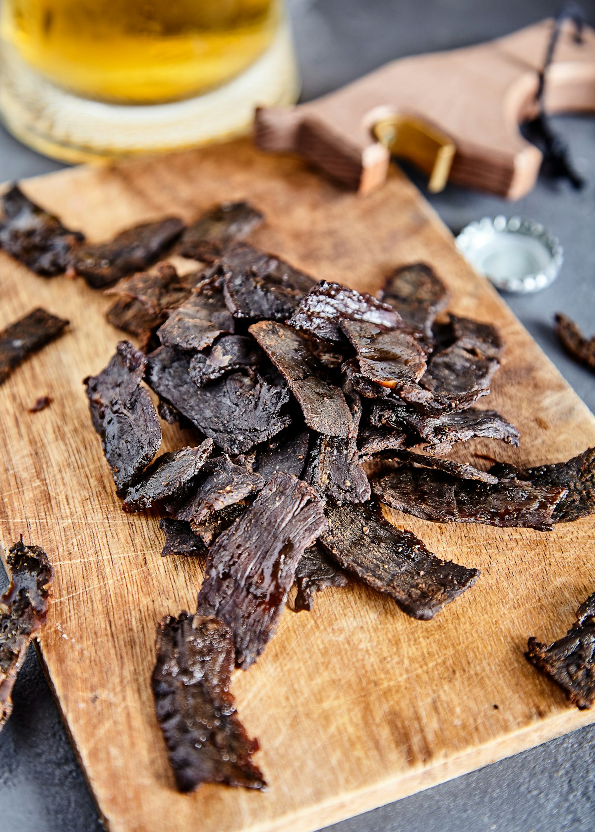Strips of beef jerky on a wooden cutting board